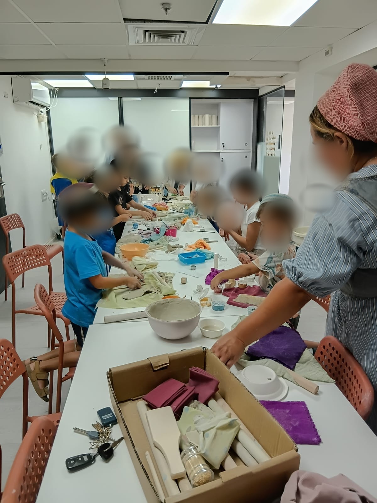 קבוצה קטנה של ילדים סביב השולחן הארוך בסטודיו