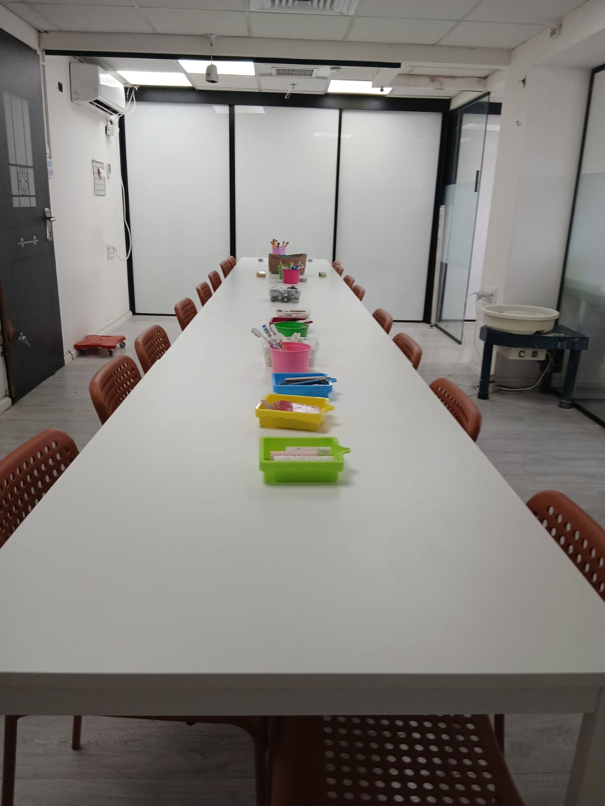 הסטודיו ערוך לסדנה – שולחן ארוך עם ערכות צביעה ואובניים