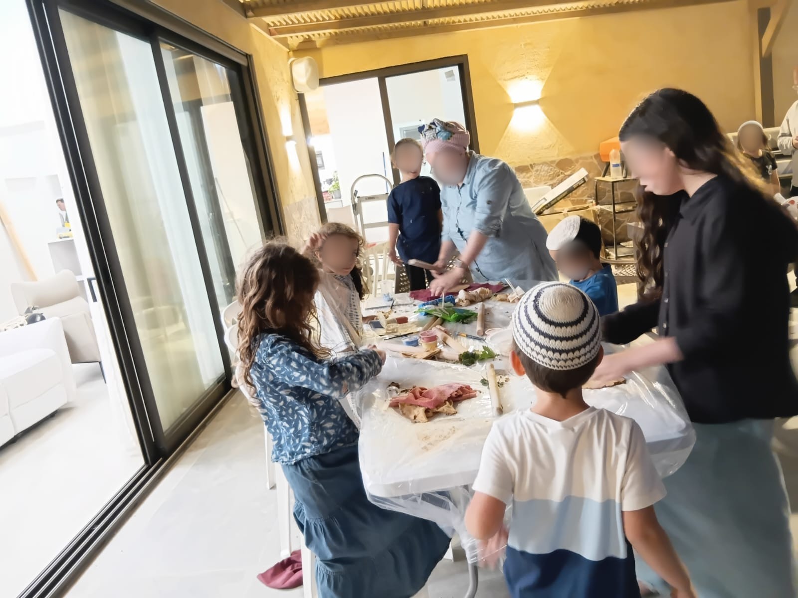 קבוצה יוצרת בחימר בסדנה במרפסת מקורה